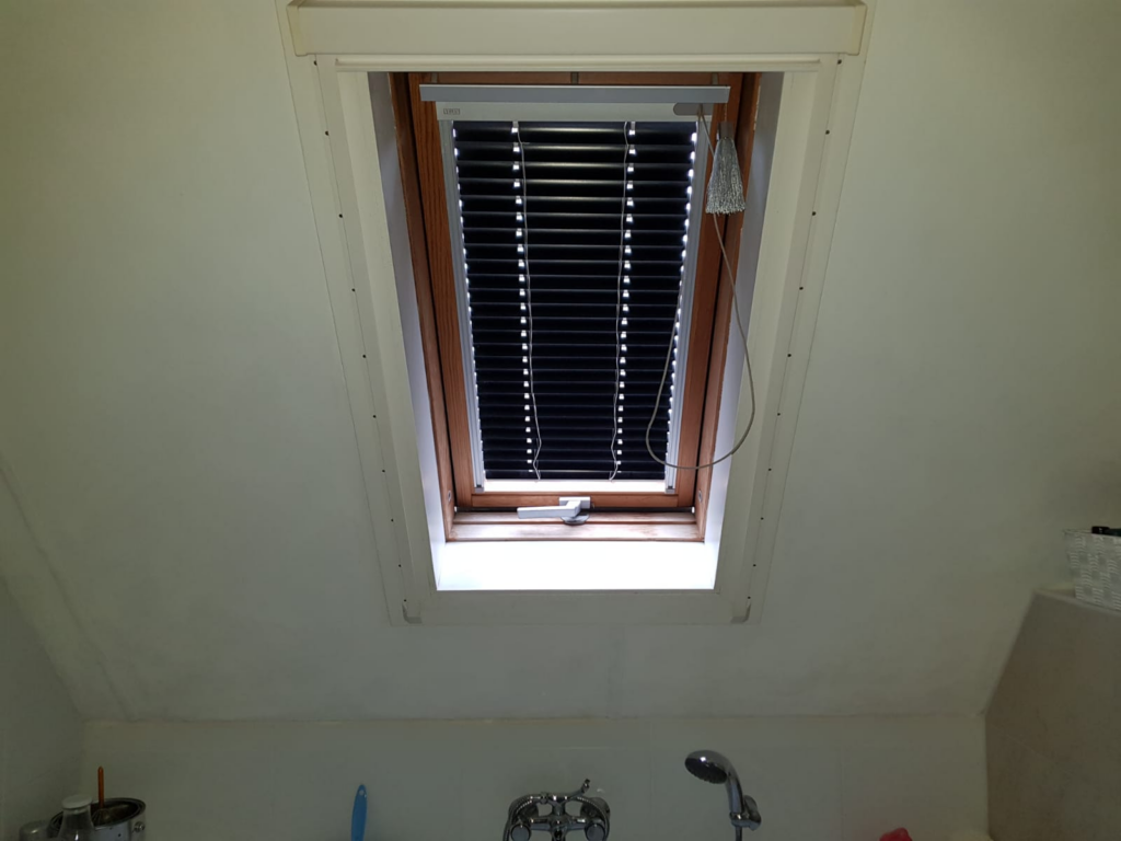Schuin plafond en douchehoek voorzien van witte kunststof wandpanelen
